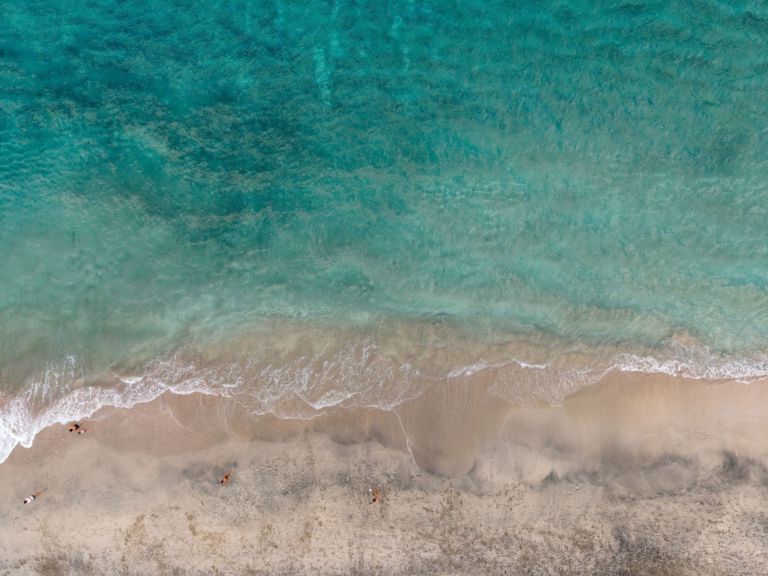 Aerial shot of pristine sandy beach and turquoise ocean in Bali, Indon